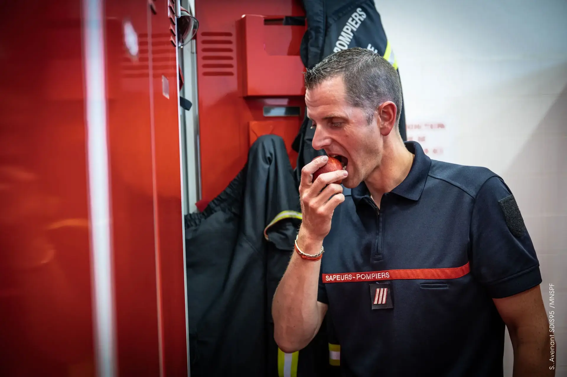 Un sapeur-pompier manger une pomme